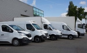 A lineup of different types of commercial vehicles outside a depot