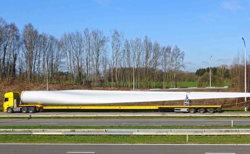 truck carrying long oversized load of wind turbine