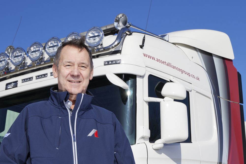 Brian Kempson, Truck and Trailer Sales Director stands infront of a branded Asset Alliance Grouptruck